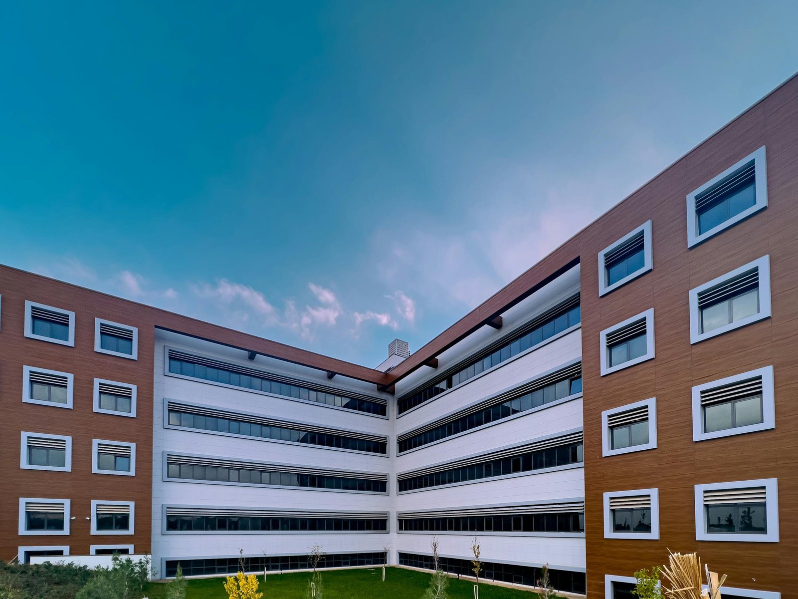 A contemporary office building with glass windows under a clear blue sky.